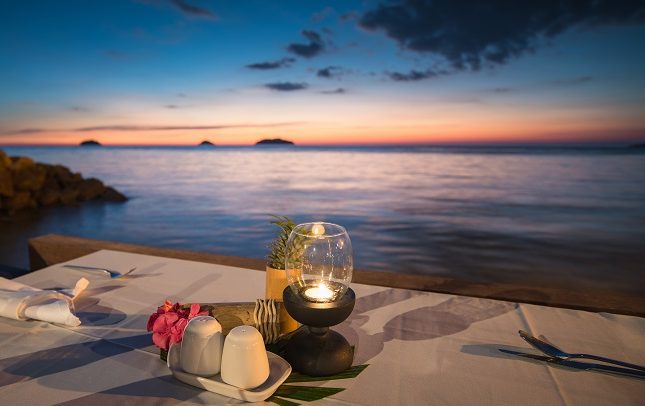 Romantic candlelit dinner table overlooking the Caribbean Sea at sunset in Montego Bay Jamaica
