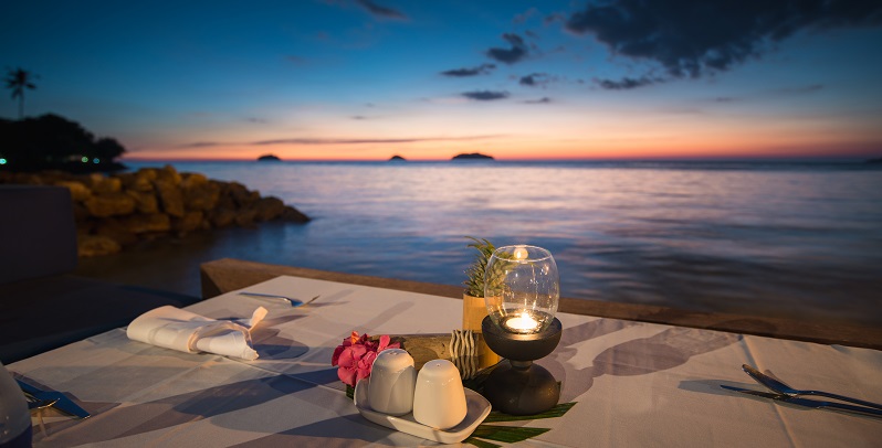 Romantic candlelit dinner table overlooking the Caribbean Sea at sunset in Montego Bay Jamaica