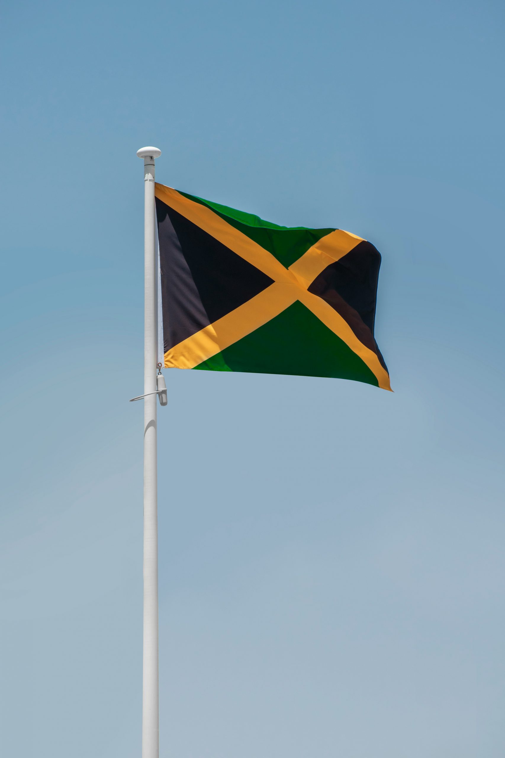 Jamaican flag against a clear blue sky