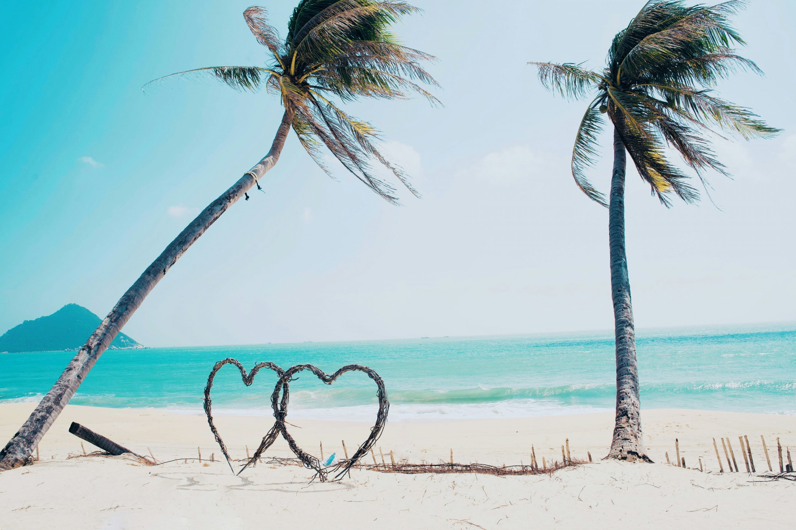 Romantic Things to Do in Montego Bay. Romantic Caribbean beach with two heart sculptures and palm trees in Montego Bay Jamaica
