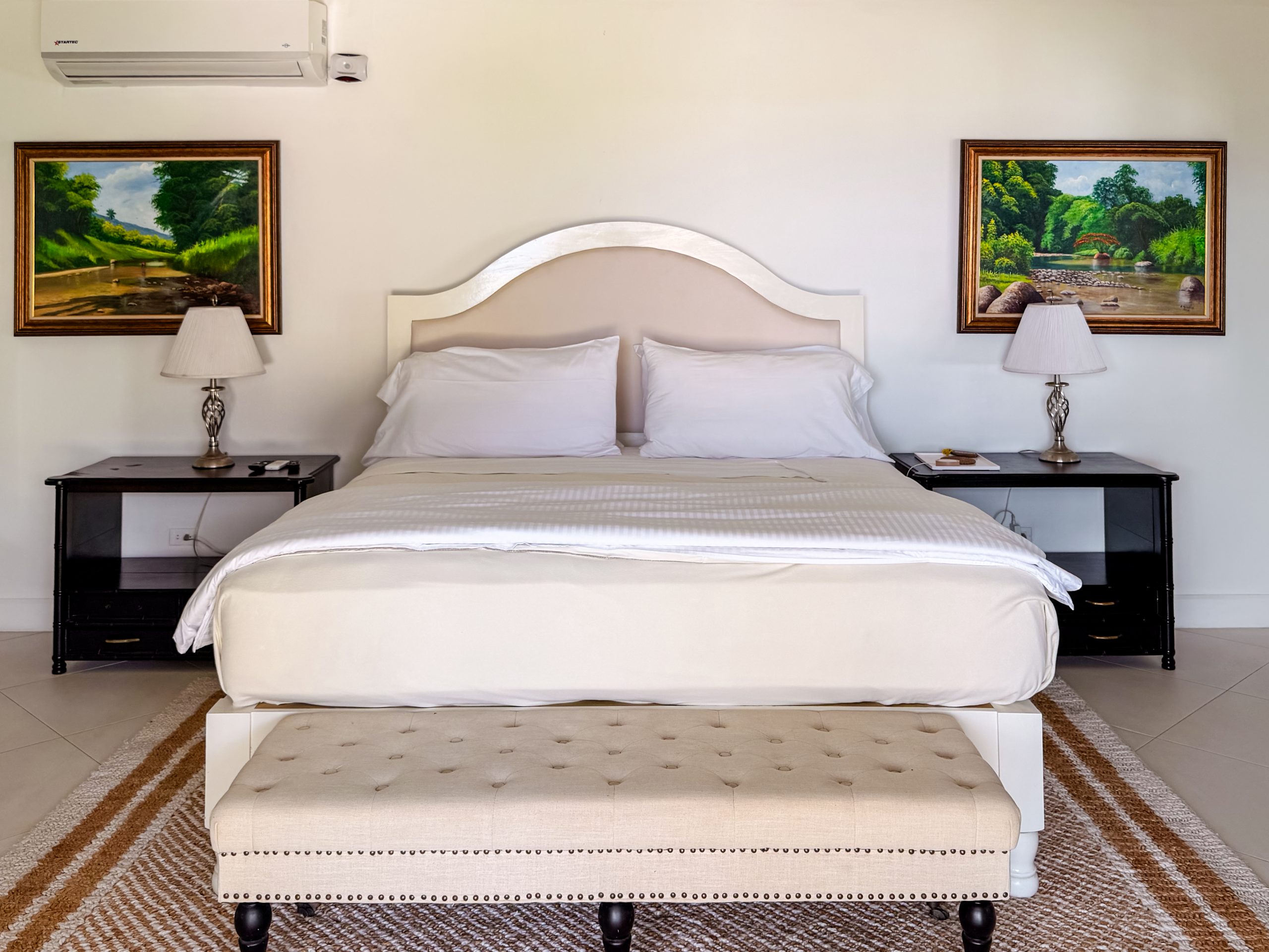 Luxury villa suite bedroom at Coconut Cottage with a tufted bench, elegant décor and a calm, private atmosphere.
