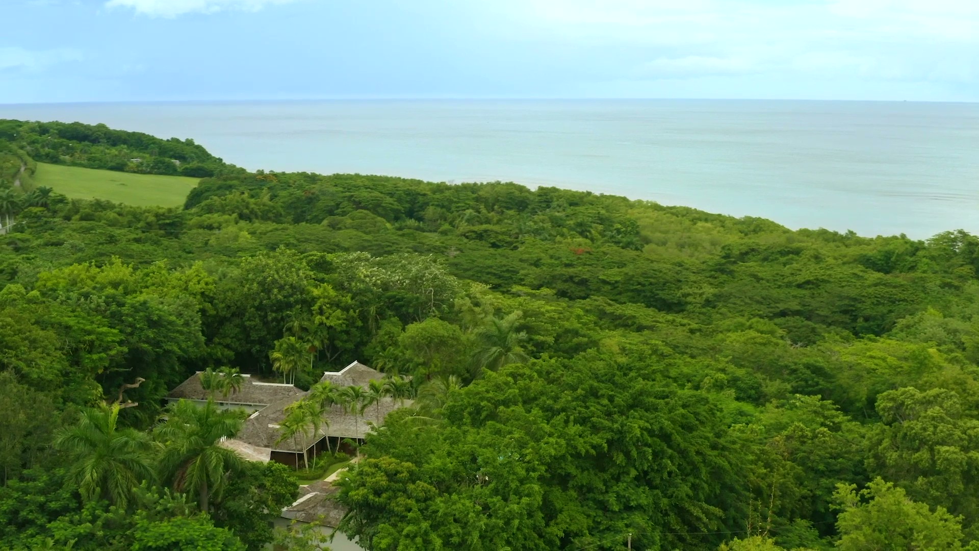 Lookout spots. Aerial view of Coconut Cottage nestled in lush tropical greenery overlooking the Caribbean Sea.