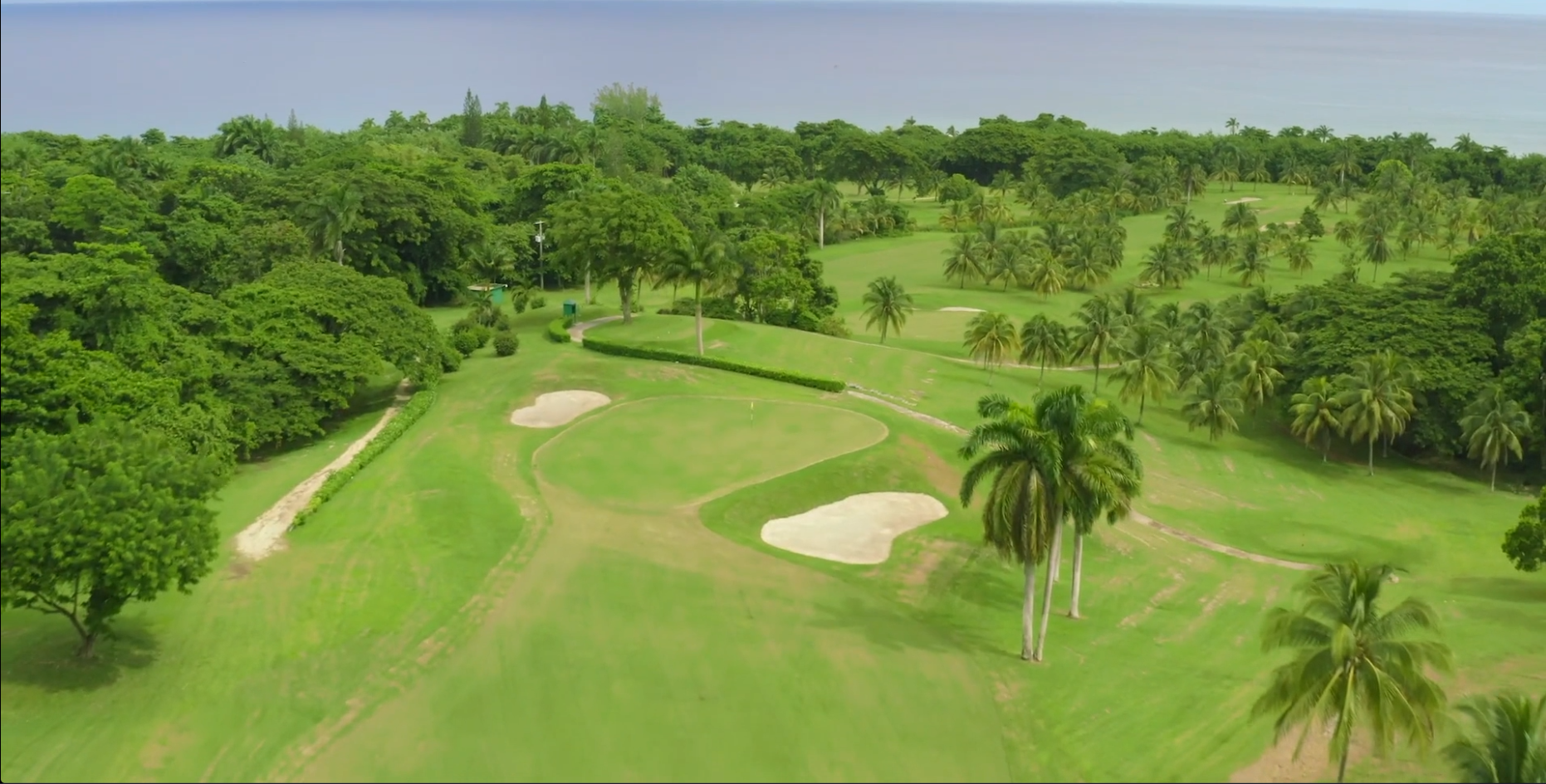 Aerial view of the Tryall Club golf course with lush fairways, palm trees and ocean views in Montego Bay.