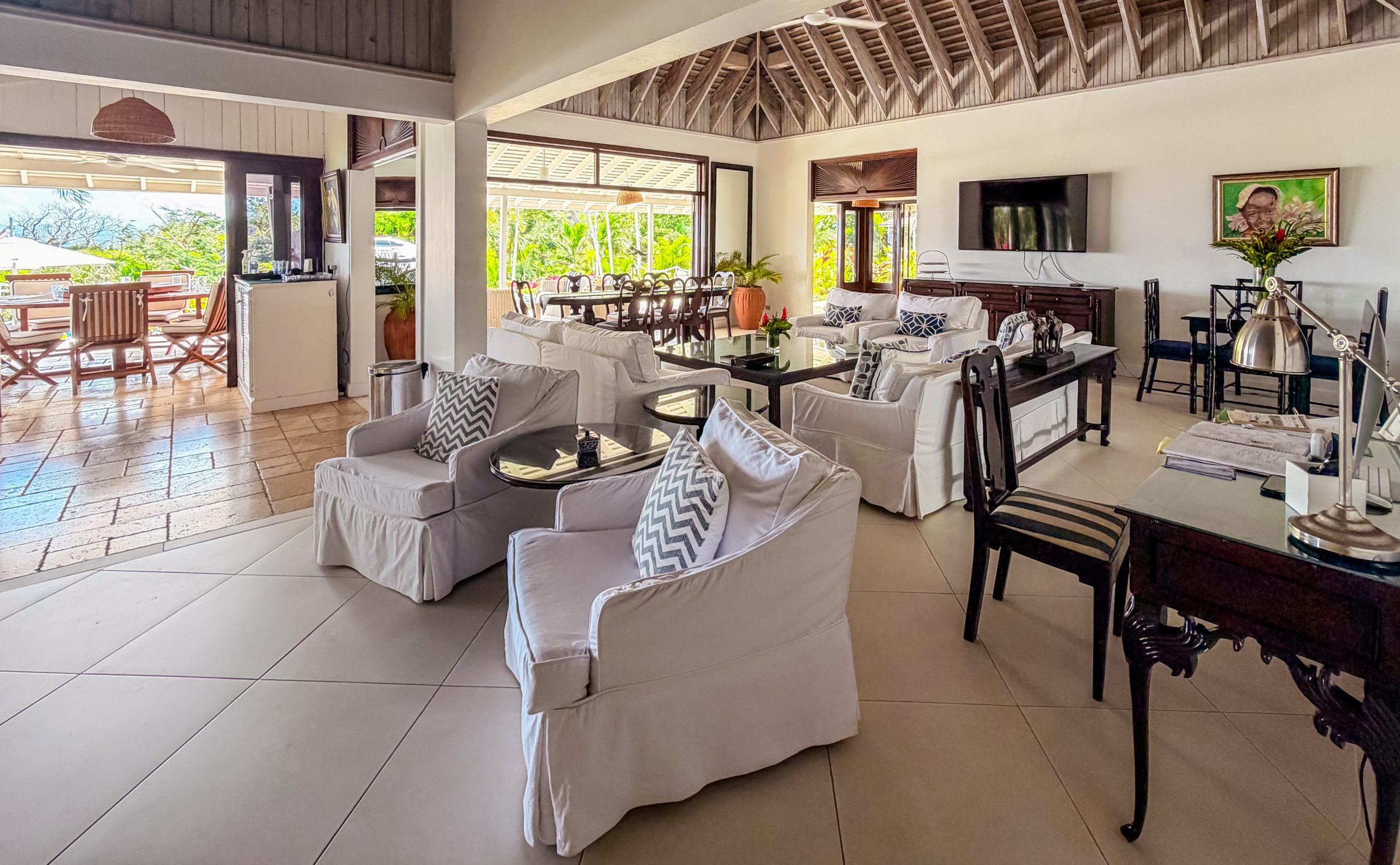 Open‑plan living and dining area at Coconut Cottage with comfortable seating, natural light and seamless indoor‑outdoor flow, creating a relaxed space for uninterrupted time together.